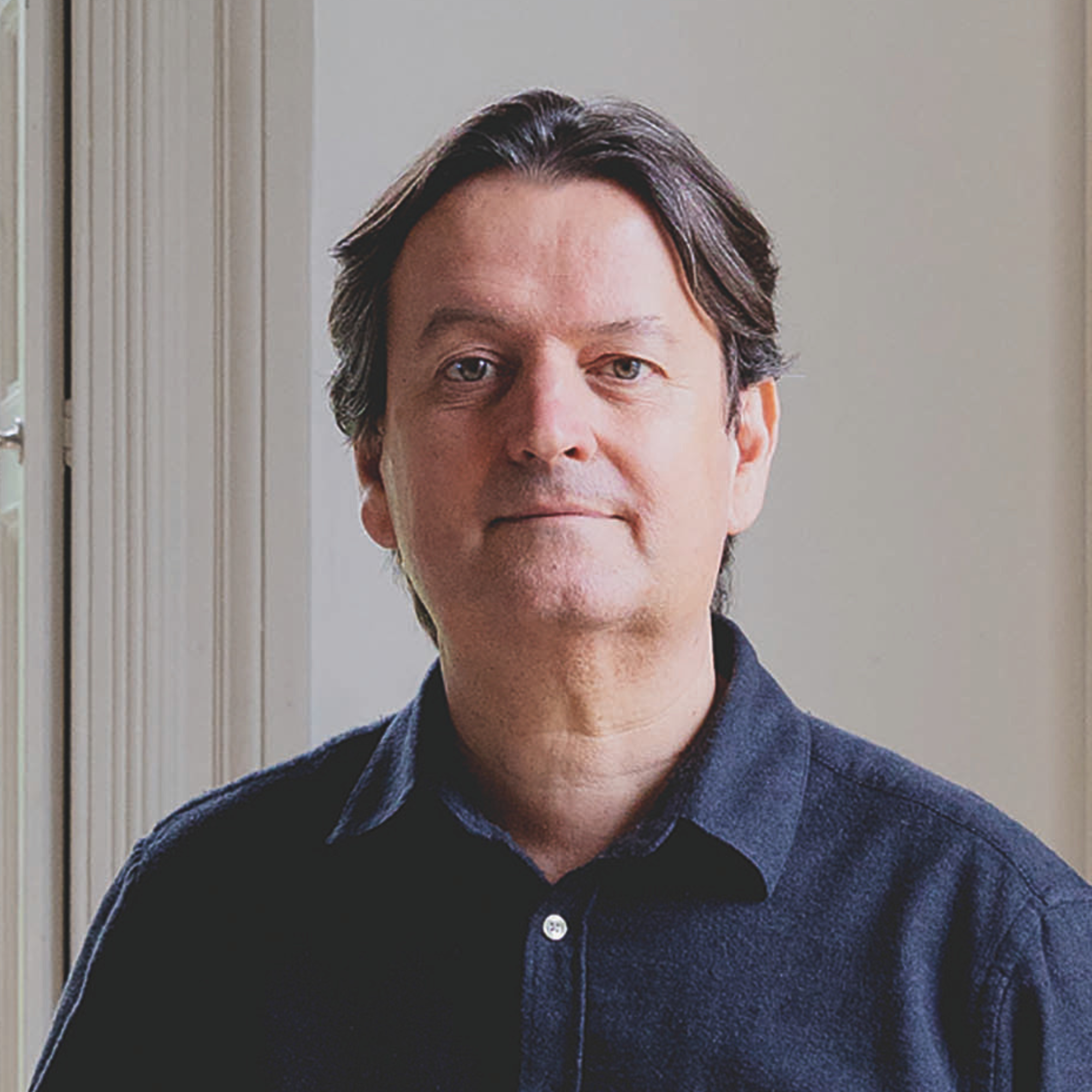 Giles Kime headshot facing camera wearing a blue shirt